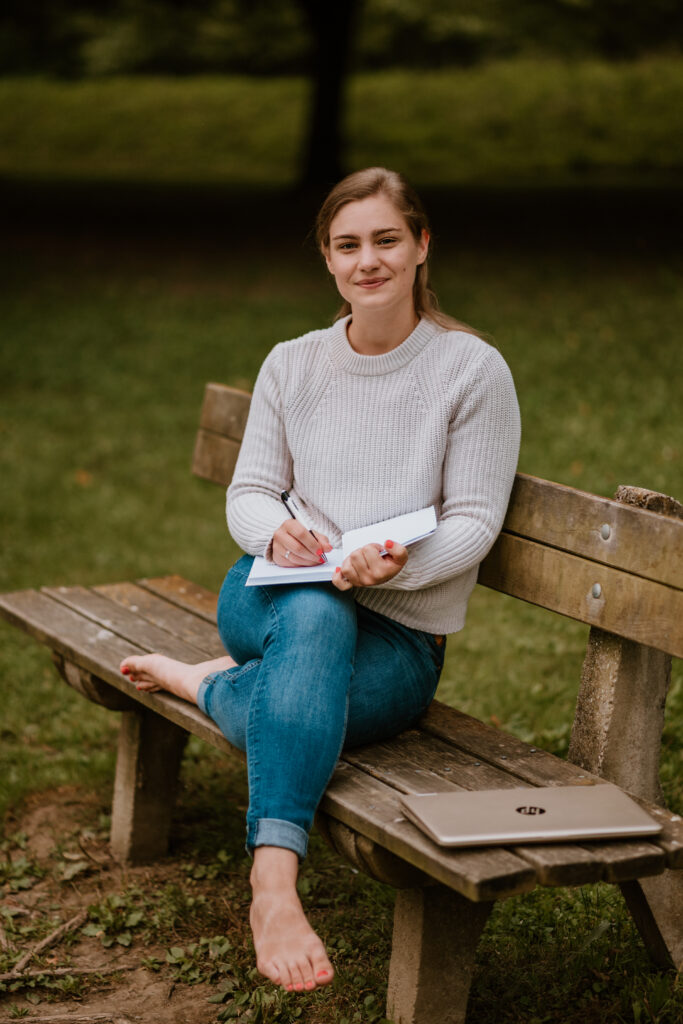 Mosolygó nő füzettel a kezében – kamaszok és szülők segítője